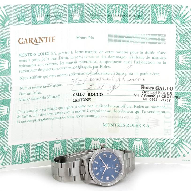 The image shows a Rolex Air-King 14010 Men's Stainless Steel Blue Dial 14010 Men's Stainless Steel Blue Dial watch from a front angle, along with its guarantee certificate in the background.