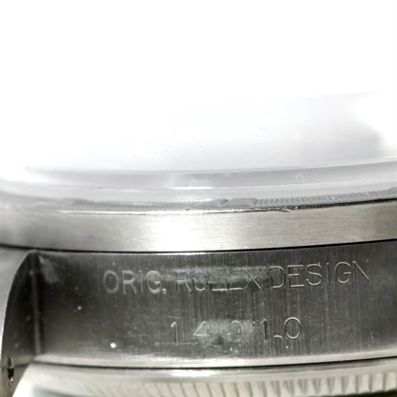 The image shows a close-up of the side of a Rolex Air-King 14010 Men's Stainless Steel Blue Dial 14010 Men's Stainless Steel Blue Dial watch case with model and "ORIG. ROLEX DESIGN" engraving.