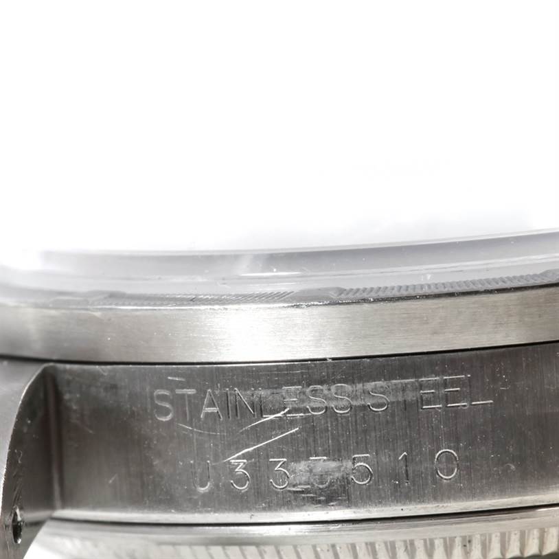 This image shows a close-up of the case and bezel of a Rolex Air-King 14010 Men's Stainless Steel Blue Dial 14010 Men's Stainless Steel Blue Dial watch, focusing on the serial number and "Stainless Steel" engraving.