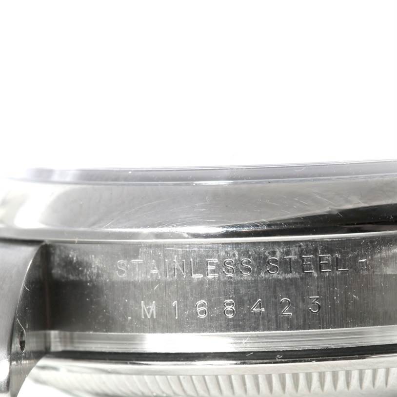 The image shows a close-up of the side of a stainless steel Rolex Air-King 114200 Men's Stainless Steel Blue Dial 114200 Men's Stainless Steel Blue Dial watch case, displaying the serial number.