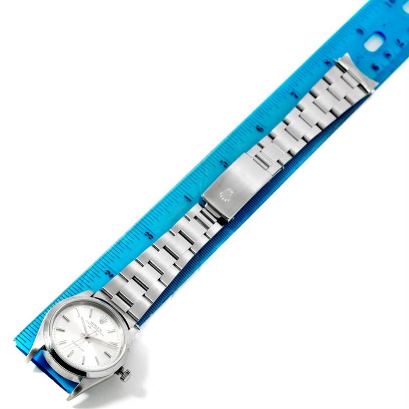 The image shows an overhead view of a Rolex Air-King 14000 Men's Stainless Steel Silver Dial 14000 Men's Stainless Steel Silver Dial watch, displaying the face, bracelet, and clasp, aligned with a blue ruler.