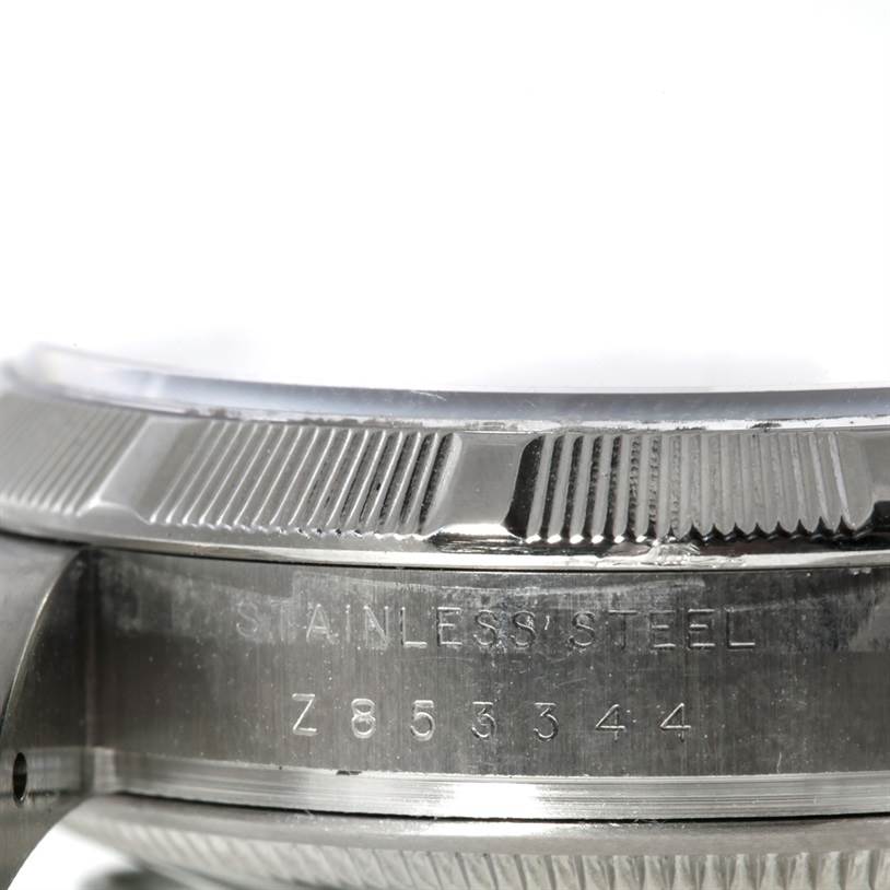 This image shows a close-up of the side of a Rolex Air-King 114200 Men's Stainless Steel Silver Dial 114200 Men's Stainless Steel Silver Dial watch, focusing on its serial number and stainless steel case.