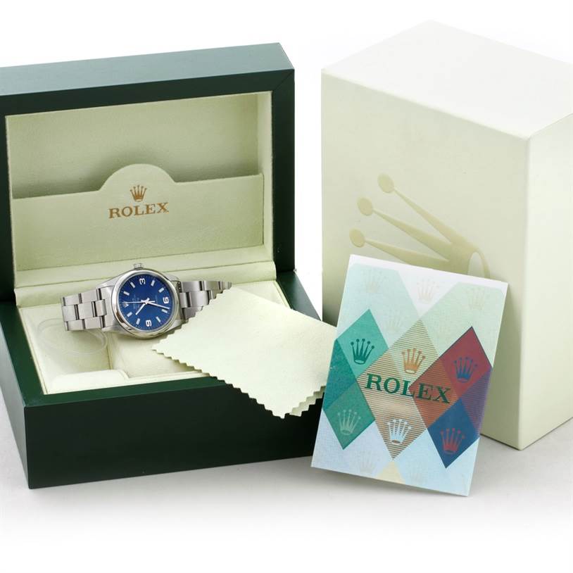 The image shows a Rolex Air-King 14000 Men's Stainless Steel Blue Dial 14000 Men's Stainless Steel Blue Dial watch in an open green box, alongside a cleaning cloth and a pamphlet.