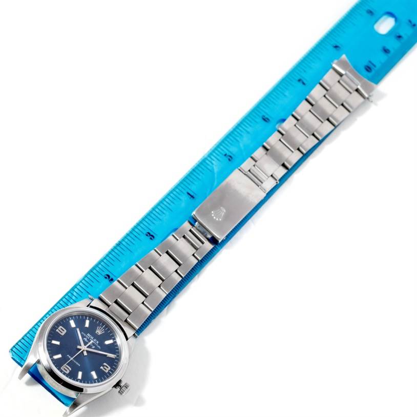 This image shows the front angle of the Rolex Air-King 14000 Men's Stainless Steel Blue Dial 14000 Men's Stainless Steel Blue Dial watch, including the face, bezel, and metal bracelet, next to a blue ruler for scale.