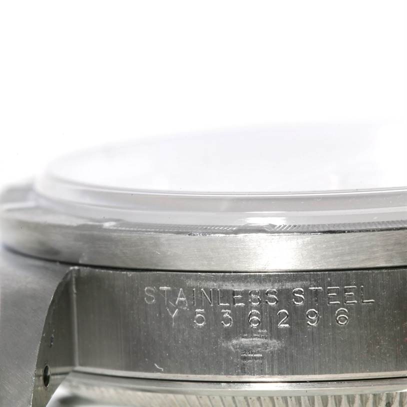 The image shows a close-up view of the side of a Rolex Air-King 14010 Men's Stainless Steel Silver Dial 14010 Men's Stainless Steel Silver Dial watch, highlighting the serial number and "Stainless Steel" engraving.