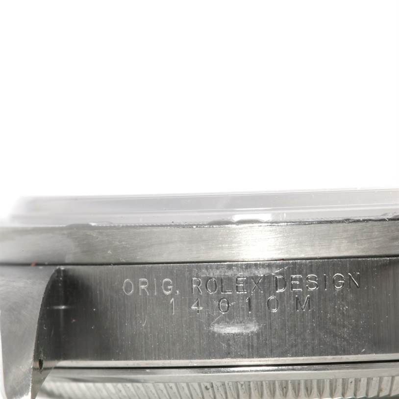 This close-up photo of the Rolex Air-King 14010 Men's Stainless Steel Silver Dial 14010 Men's Stainless Steel Silver Dial watch shows the side engraving with "ORIG. ROLEX DESIGN" and model number "14010M."