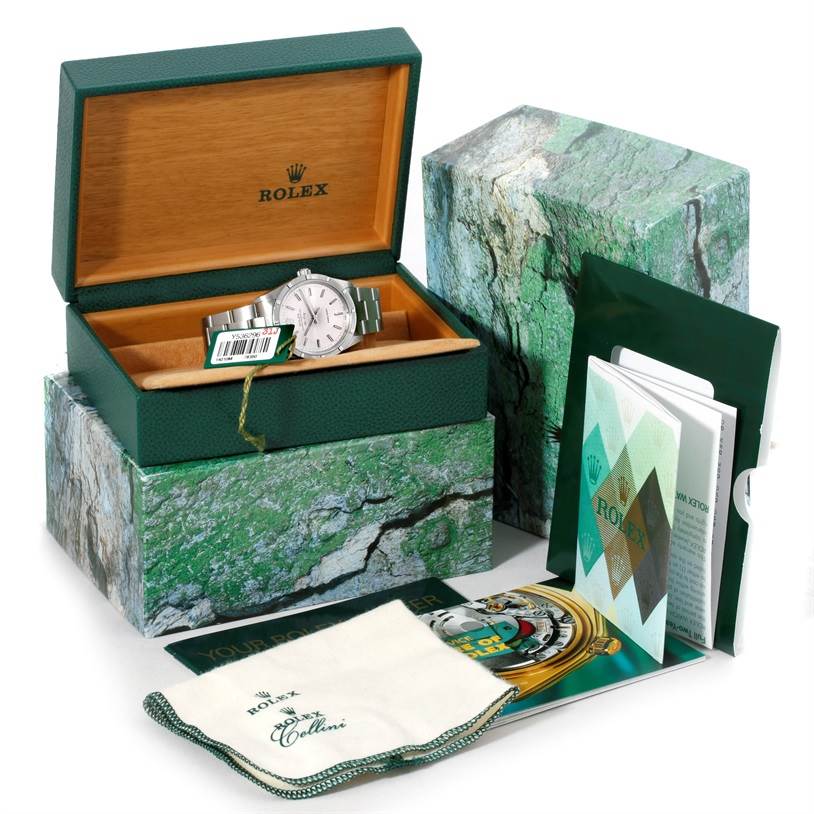 The Rolex Air-King 14010 Men's Stainless Steel Silver Dial 14010 Men's Stainless Steel Silver Dial watch is shown inside its green wooden box, along with its outer box, manuals, and cleaning cloth.