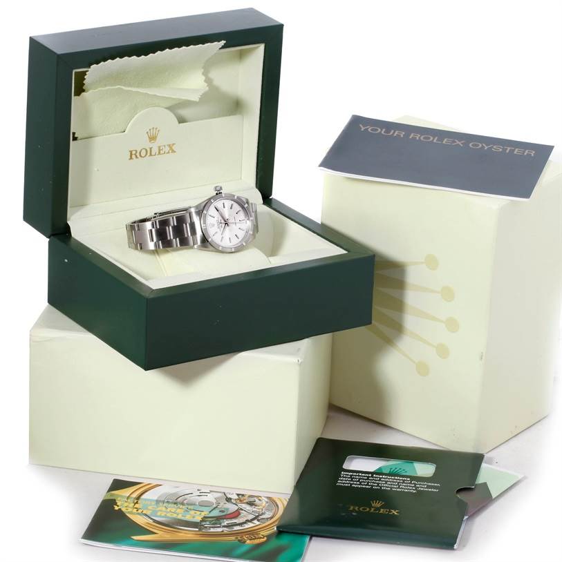 The Rolex Air-King 14010 Men's Stainless Steel Silver Dial 14010 Men's Stainless Steel Silver Dial watch is shown at a front angle in its open box, alongside booklets and other packaging materials.