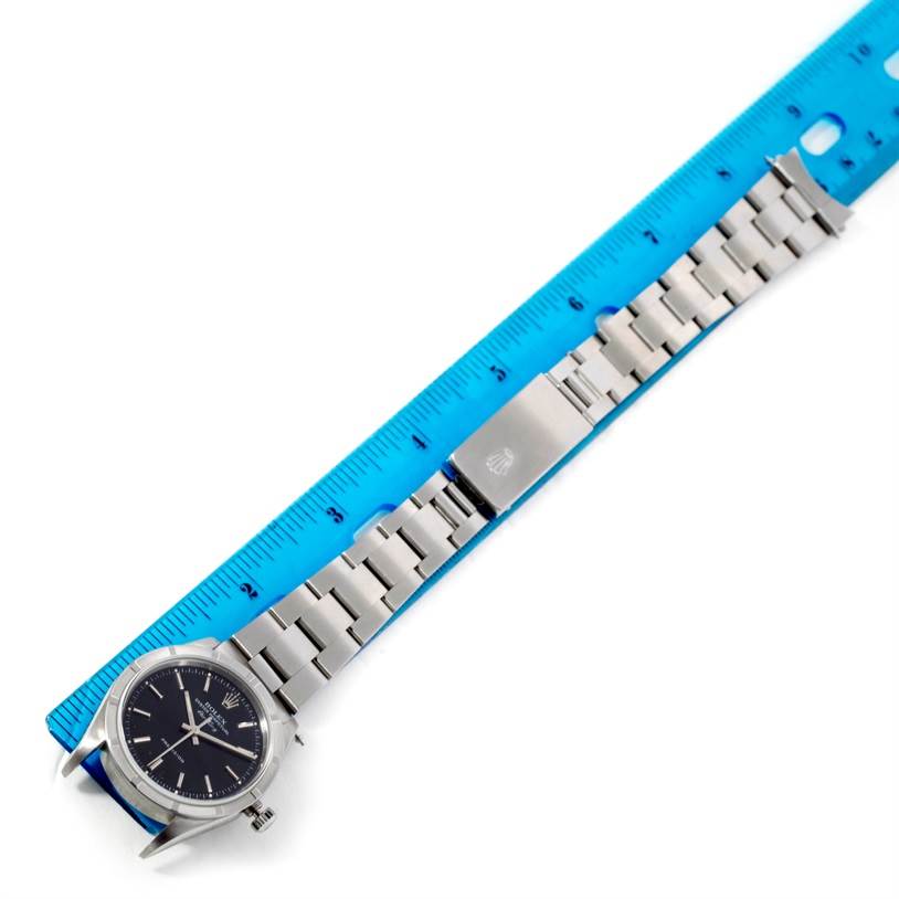 The image shows a Rolex Air-King 14010 Men's Stainless Steel Black Dial 14010 Men's Stainless Steel Black Dial watch laid flat next to a blue ruler, displaying the watch face, bracelet, and clasp.