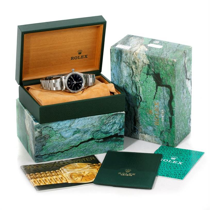 The Rolex Air-King 14010 Men's Stainless Steel Black Dial 14010 Men's Stainless Steel Black Dial watch is shown at an angle inside an open green box, with additional boxes and booklets displayed.