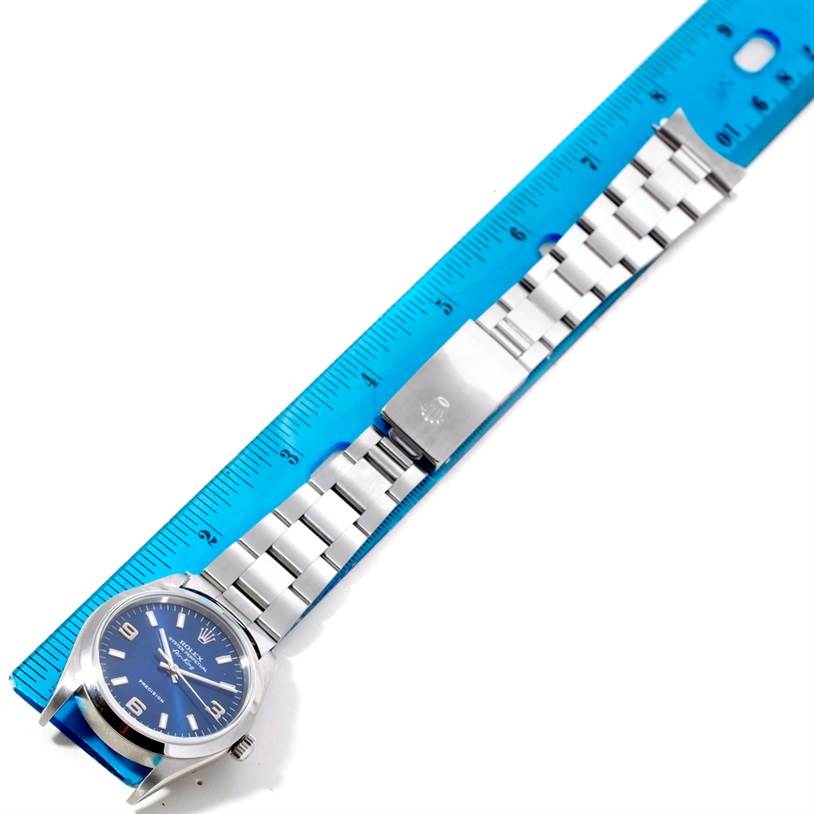 The image shows a top view of a Rolex Air-King 14000 Men's Stainless Steel Blue Dial 14000 Men's Stainless Steel Blue Dial watch, including its face and stainless steel band, placed next to a ruler.
