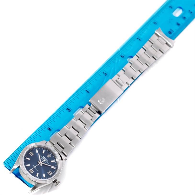 The image shows a top-down view of the Rolex Air-King 14010 Men's Stainless Steel Blue Dial 14010 Men's Stainless Steel Blue Dial watch, highlighting its face, bracelet, and clasp alongside a ruler for scale.