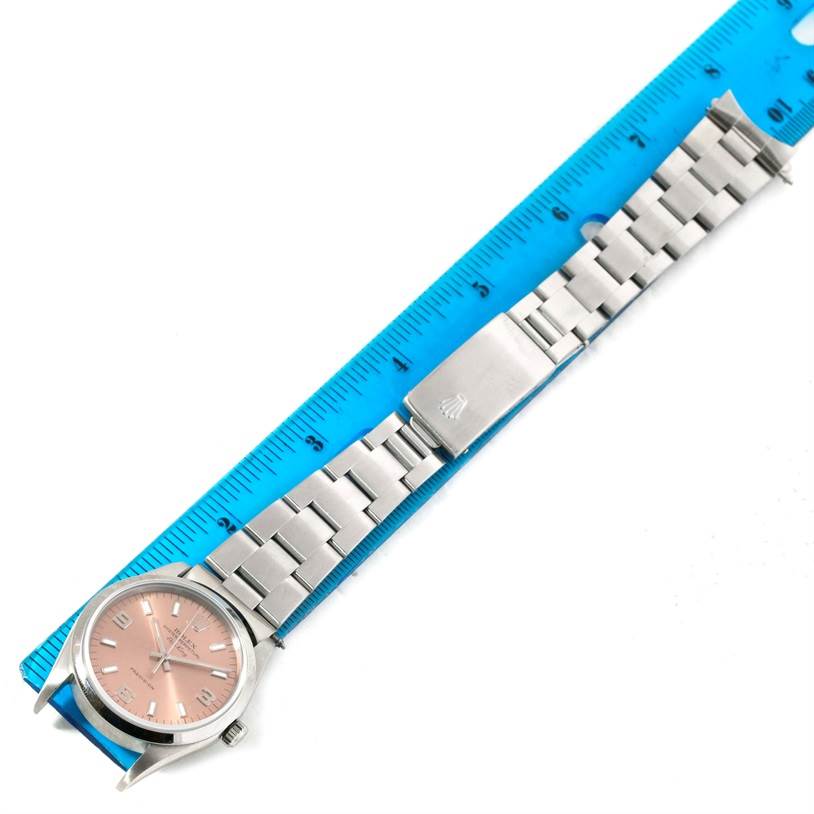 The Rolex Air-King 14000 Men's Stainless Steel Pink Dial 14000 Men's Stainless Steel Pink Dial watch is displayed flat, showing its face, bracelet, and clasp, measured against a blue ruler.