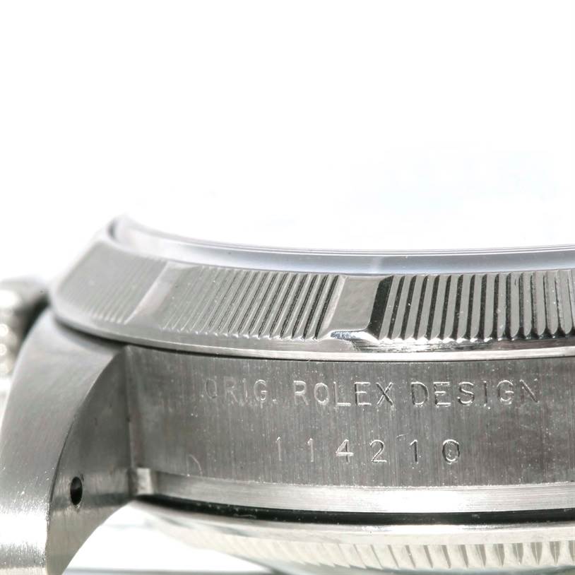 The image shows a close-up side view of the bezel and case of a Rolex Air-King 114210 Men's Stainless Steel Blue Dial 114210 Men's Stainless Steel Blue Dial watch, with "ORIG. ROLEX DESIGN" and the model number engraved.