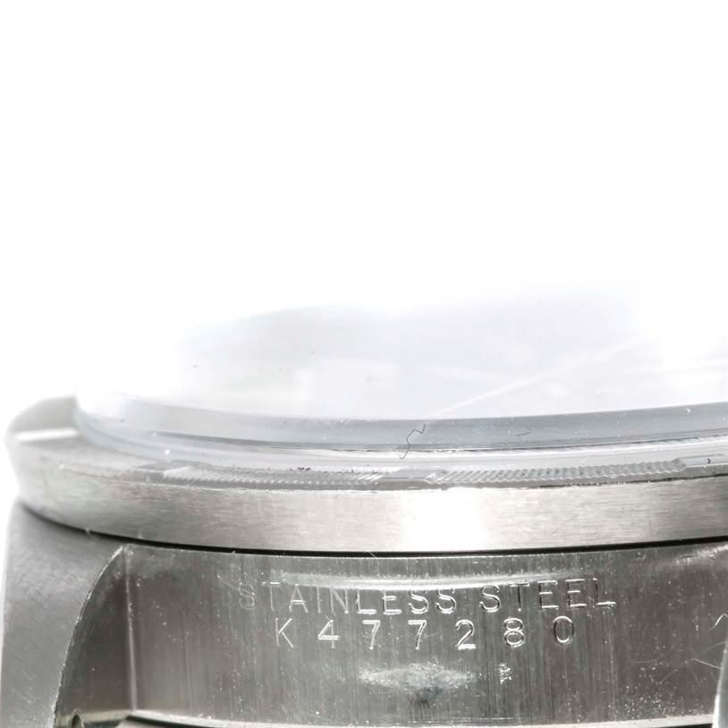 This close-up image of a Rolex Air-King 14010 Men's Stainless Steel Black Dial 14010 Men's Stainless Steel Black Dial watch shows the stainless steel case with its serial number and part of the bezel and crystal.