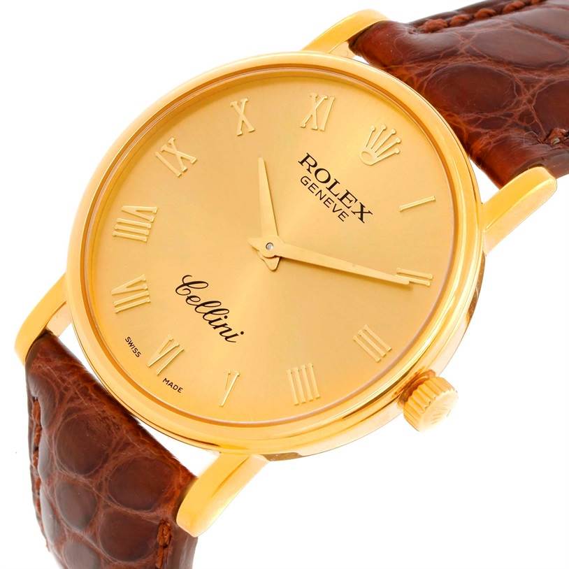 The image shows a close-up angle of the Rolex Cellini 5115 Men
s Yellow Gold Champagne Dial 5115 Men
s Yellow Gold Champagne Dial watch face and crown with a brown leather strap.