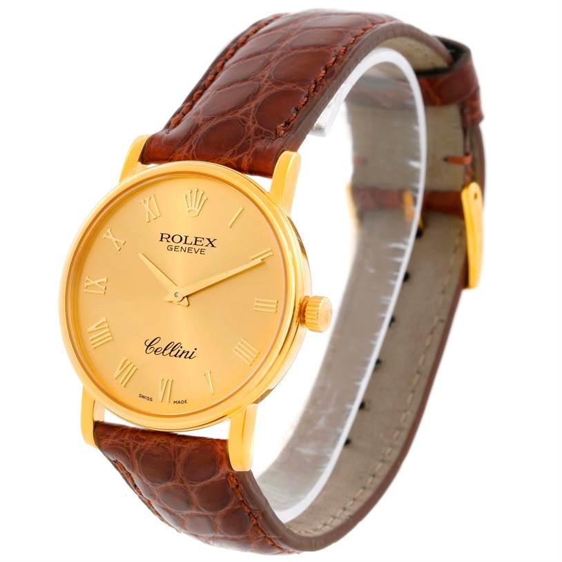The Rolex Cellini 5115 Men
s Yellow Gold Champagne Dial 5115 Men
s Yellow Gold Champagne Dial watch is shown at an angle displaying the gold case, dial with Roman numerals, crown, and brown leather strap.