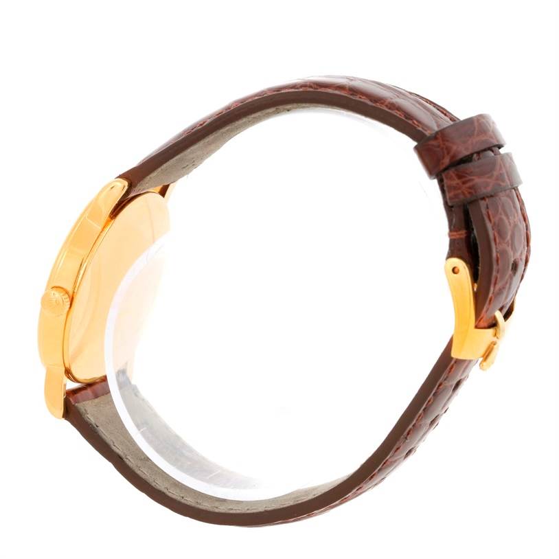 The image shows a side view of a Rolex Cellini 5115 Men
s Yellow Gold Champagne Dial 5115 Men
s Yellow Gold Champagne Dial watch, highlighting its gold case and brown leather strap with a buckle.