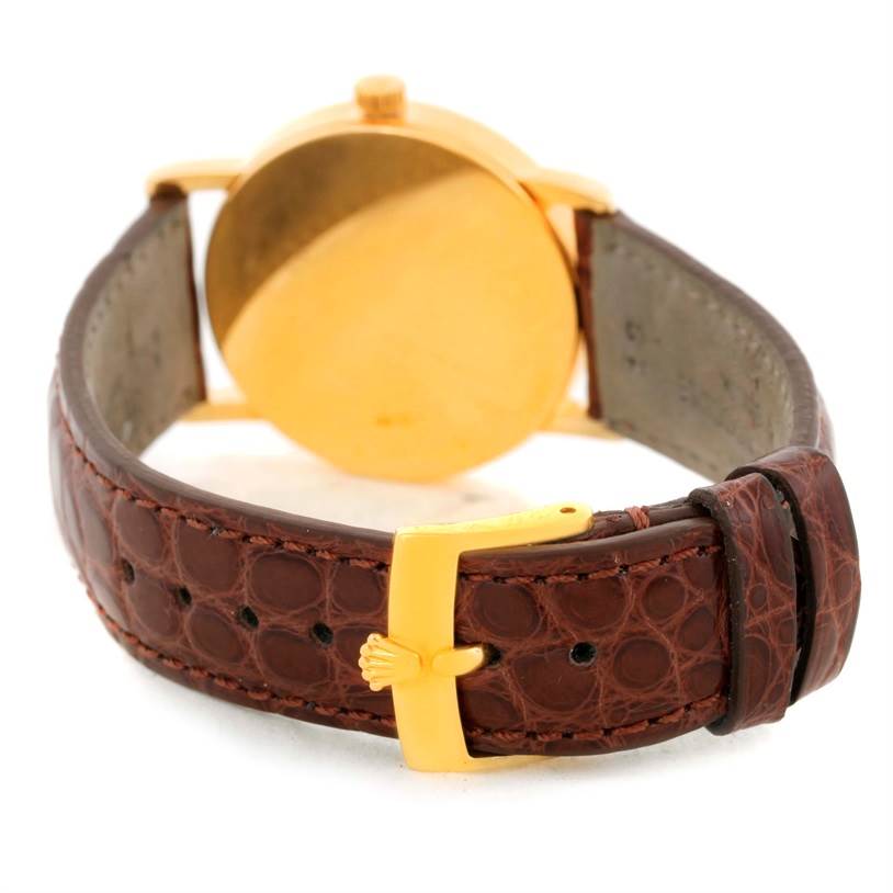 The image shows the back of a Rolex Cellini 5115 Men
s Yellow Gold Champagne Dial 5115 Men
s Yellow Gold Champagne Dial watch with a focus on its brown leather strap and gold clasp.