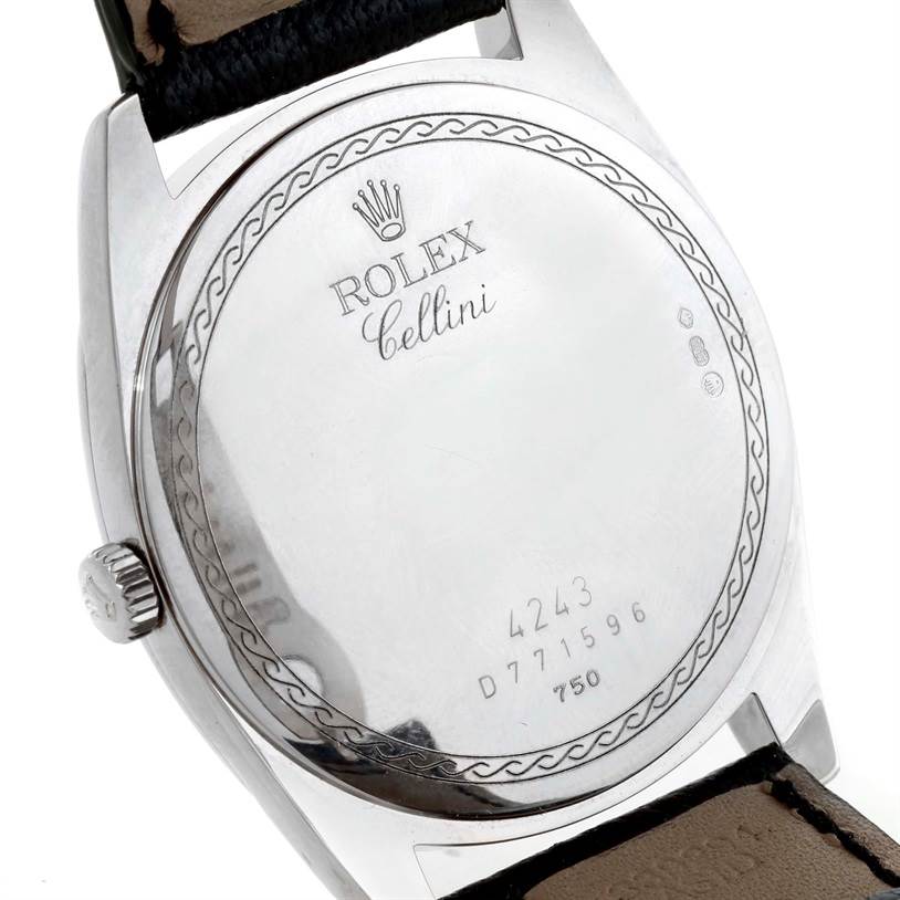 The image shows the back of a Rolex Cellini 4243 Men's White Gold Black Dial 4243 Men's White Gold Black Dial watch, highlighting its engravings and the crown part of its leather strap.