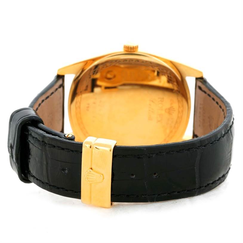 The image shows the back view of a Rolex Cellini 4243 Men's Yellow Gold White Dial 4243 Men's Yellow Gold White Dial watch highlighting the case back, gold crown, and black leather strap with a gold clasp.