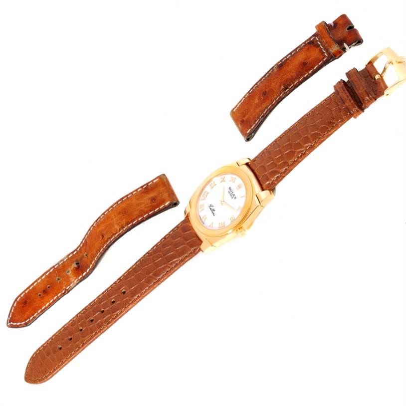 The image shows a Rolex Cellini 5330 Men's Yellow Gold White Dial 5330 Men's Yellow Gold White Dial watch with a brown leather strap, along with two additional strap pieces, all viewed from above.