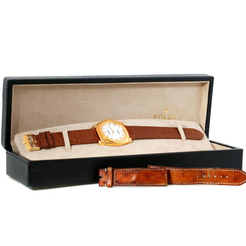 The image shows a Rolex Cellini 5330 Men's Yellow Gold White Dial 5330 Men's Yellow Gold White Dial watch with a brown leather strap in its box, accompanied by an extra band.
