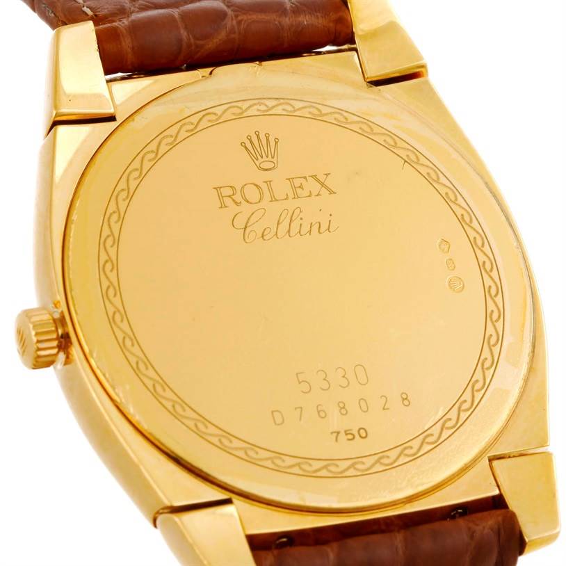 This is the back view of a Rolex Cellini 5330 Men's Yellow Gold White Dial 5330 Men's Yellow Gold White Dial watch featuring its engraved case back and part of the leather strap.