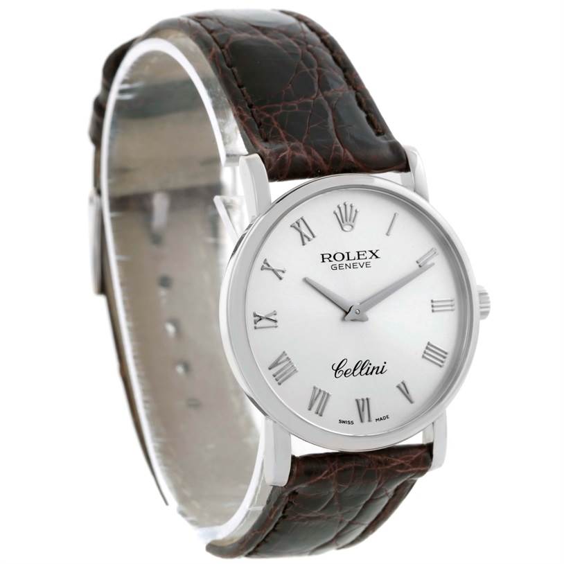 The Rolex Cellini 5115 Men's White Gold Silver Dial 5115 Men's White Gold Silver Dial watch is shown at an angled side view, highlighting its round dial, Roman numerals, and leather strap.