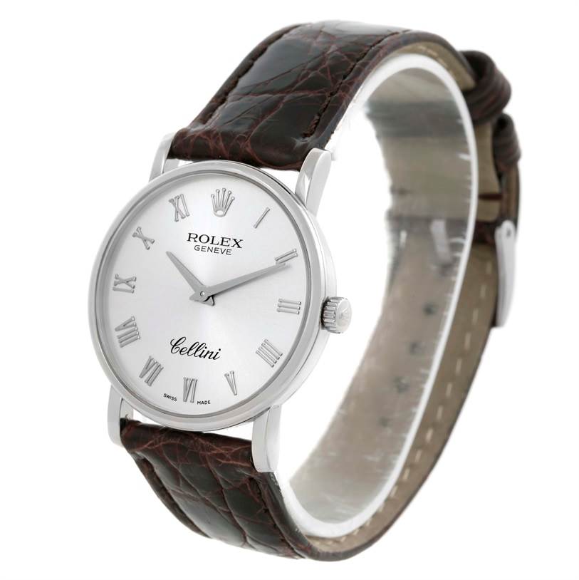 The image shows a Rolex Cellini 5115 Men's White Gold Silver Dial 5115 Men's White Gold Silver Dial watch at an angled view, featuring its white dial, Roman numerals, crown, and brown leather strap.