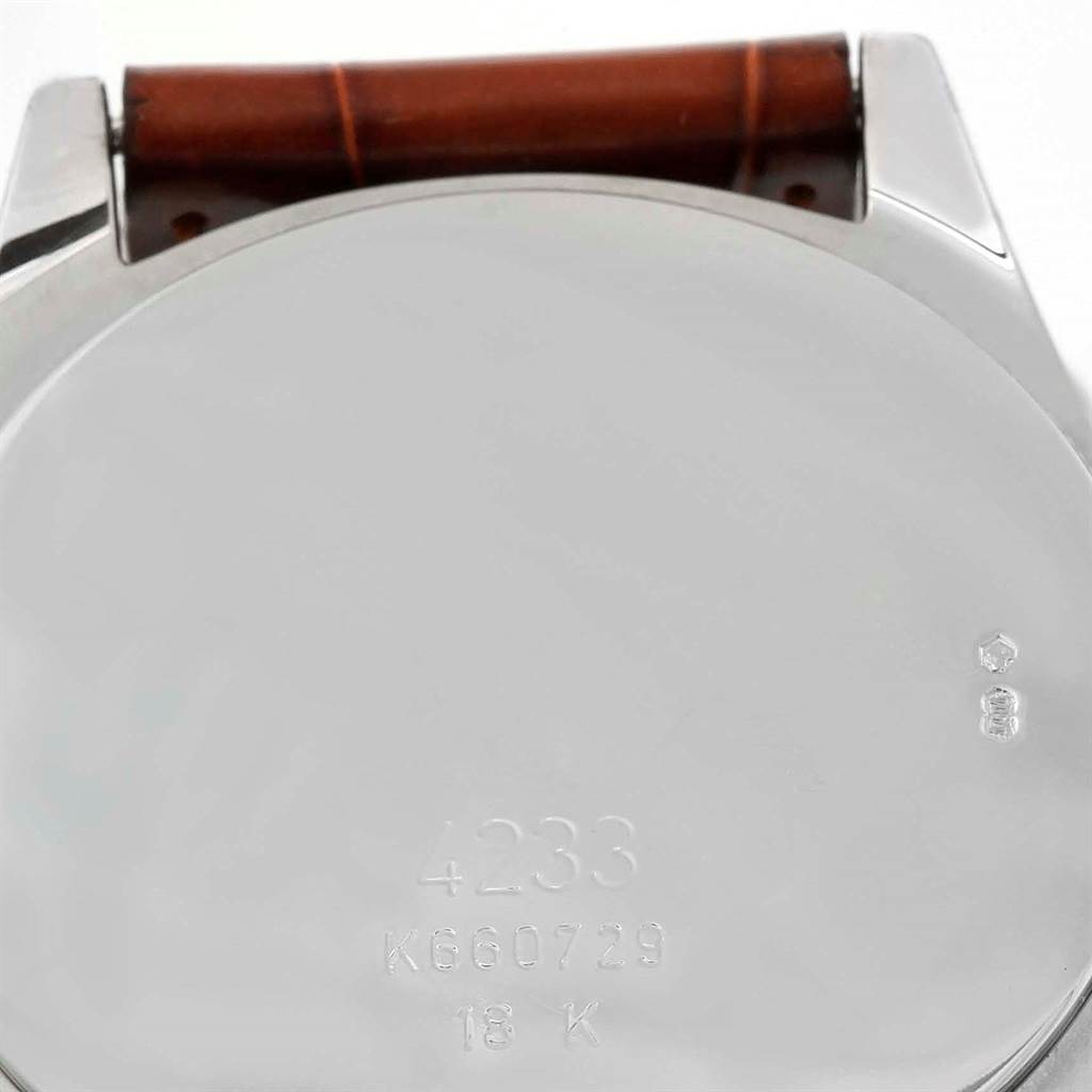 The image shows the back case of a Rolex Cellini 4233 Men's White Gold Black Dial 4233 Men's White Gold Black Dial watch, including its serial and model numbers, with part of the brown leather strap visible.