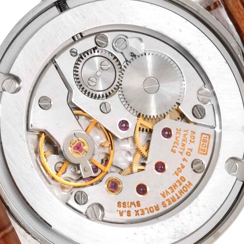 The image shows a close-up of the movement of a Rolex Cellini 5116 Men's White Gold Silver Dial 5116 Men's White Gold Silver Dial watch, revealing its intricate gears and components.
