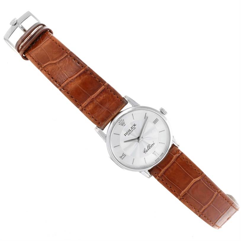The Rolex Cellini 5116 Men's White Gold Silver Dial 5116 Men's White Gold Silver Dial watch is shown at a slight diagonal angle, displaying its face and brown leather strap.