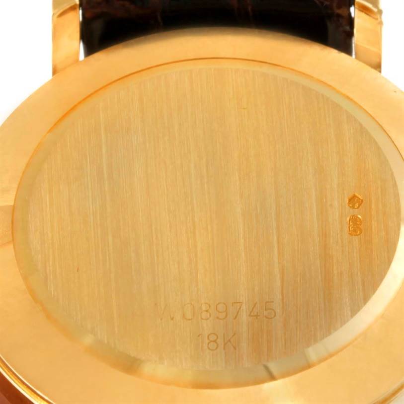 The image shows the back casing of a Rolex Cellini 5112 Men
s Yellow Gold Champagne Dial 5112 Men
s Yellow Gold Champagne Dial watch, featuring its serial number and 18K gold marking.
