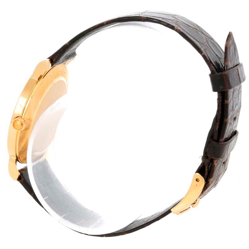 The image shows a side view of a Rolex Cellini 5112 Men
s Yellow Gold Champagne Dial 5112 Men
s Yellow Gold Champagne Dial watch, highlighting the crown, gold case, and leather strap.