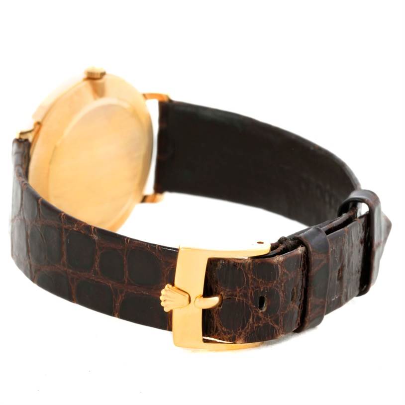 The image shows the back and side view of the Rolex Cellini 5112 Men
s Yellow Gold Champagne Dial 5112 Men
s Yellow Gold Champagne Dial watch, highlighting its leather strap and golden buckle.