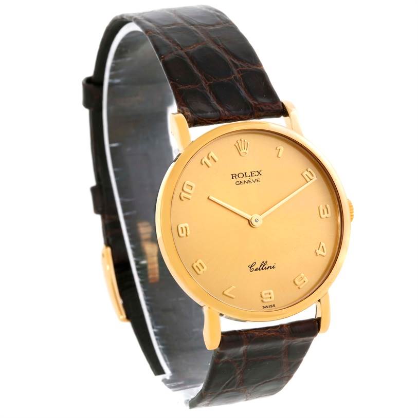 The image shows an angled view of a Rolex Cellini 5112 Men
s Yellow Gold Champagne Dial 5112 Men
s Yellow Gold Champagne Dial watch, highlighting its gold bezel, dial, and leather strap.