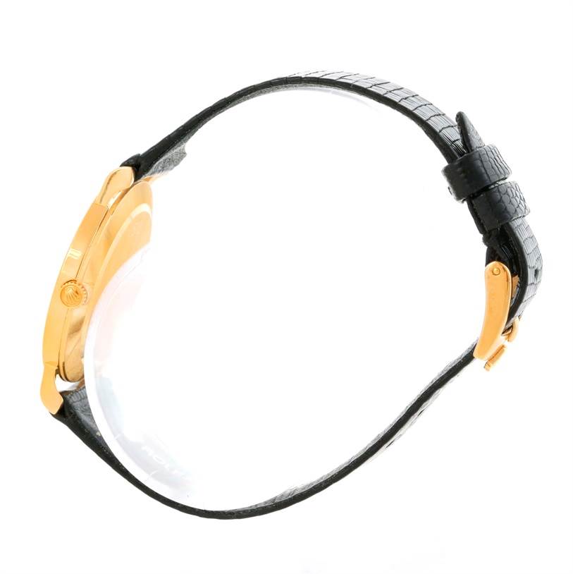 The image shows a side view of a Rolex Cellini 5112 Men's Yellow Gold Beige Dial 5112 Men's Yellow Gold Beige Dial watch, highlighting its black strap and gold case.