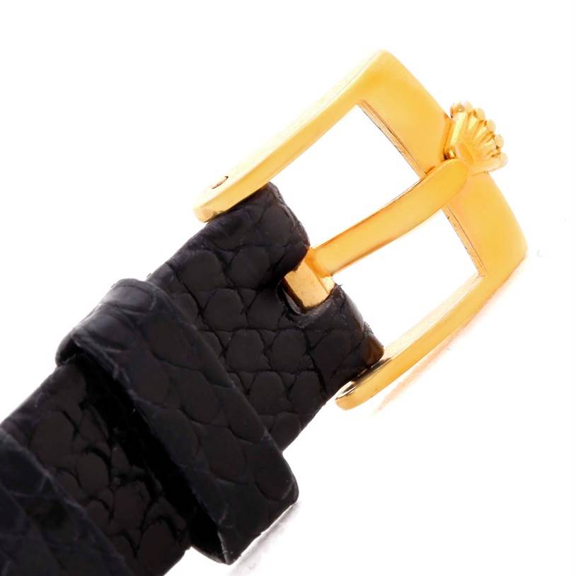 This image shows the gold buckle and black leather strap of a Cellini watch by Rolex, viewed from an angled close-up perspective.