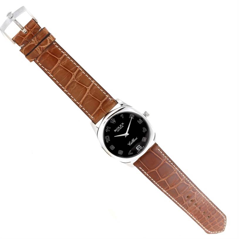 The Rolex Cellini 4233 Men's White Gold Black Dial 4233 Men's White Gold Black Dial watch is shown from a top-down angle, displaying the black dial, silver case, and brown leather strap.