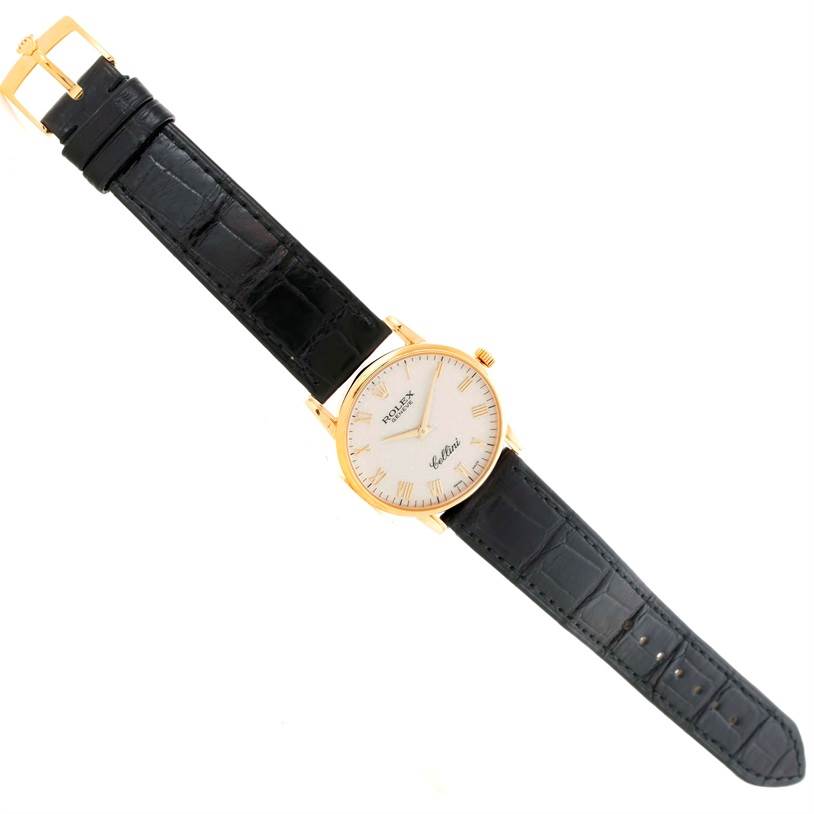 The Rolex Cellini 5116 Men's Yellow Gold Beige Dial 5116 Men's Yellow Gold Beige Dial watch is shown from a top-down angle, highlighting its face, black leather strap, and gold buckle.