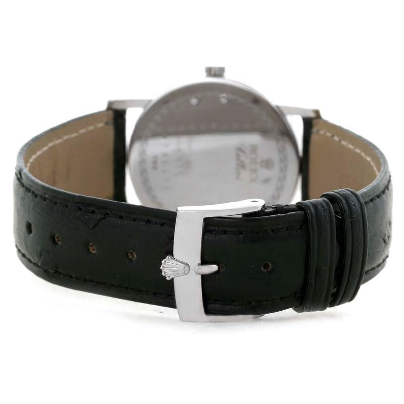 The image shows the back of a Rolex Cellini 5115 Men's White Gold Silver Dial 5115 Men's White Gold Silver Dial watch with a focus on the black leather strap and silver buckle clasp.