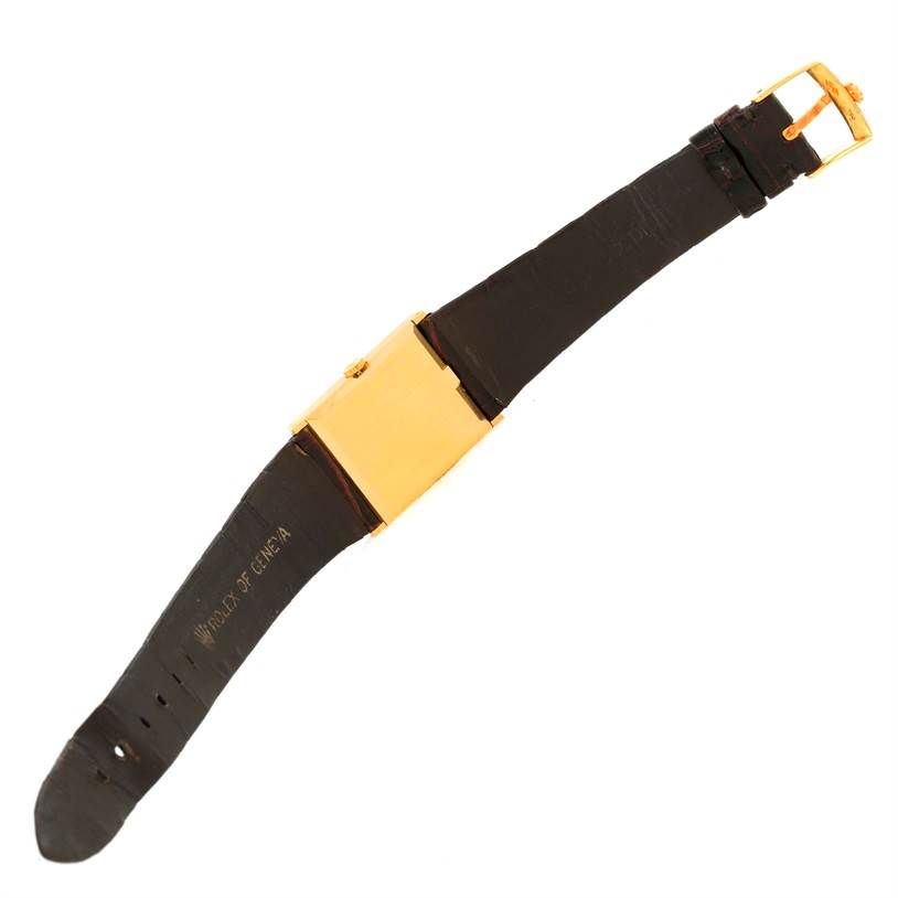 The image shows the Rolex Cellini 4127 Men
s Yellow Gold Champagne Dial 4127 Men
s Yellow Gold Champagne Dial watch laid flat, displaying its strap and the side of the square case.