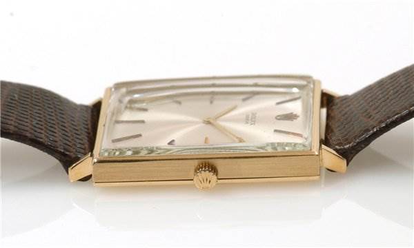 The image shows a side view of a Rolex Cellini 3607 Men's Yellow Gold Silver Dial 3607 Men's Yellow Gold Silver Dial watch, highlighting the gold rectangular case, the dial, and crown, with parts of the leather strap visible.