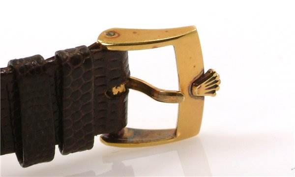 This image shows a close-up of the gold buckle and brown leather strap of a Rolex Cellini 3607 Men's Yellow Gold Silver Dial 3607 Men's Yellow Gold Silver Dial watch.