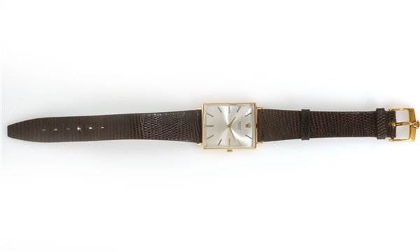 The Rolex Cellini 3607 Men's Yellow Gold Silver Dial 3607 Men's Yellow Gold Silver Dial watch is shown from a top-down angle, displaying its brown leather strap and square silver dial.