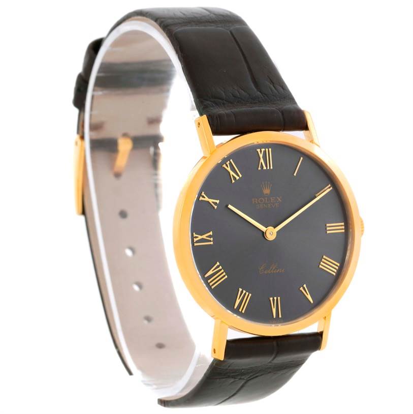 The Rolex Cellini 4112 Men
s Yellow Gold Grey Dial 4112 Men
s Yellow Gold Grey Dial watch is shown at a three-quarter angle, highlighting its black leather strap and gold case with a black dial.