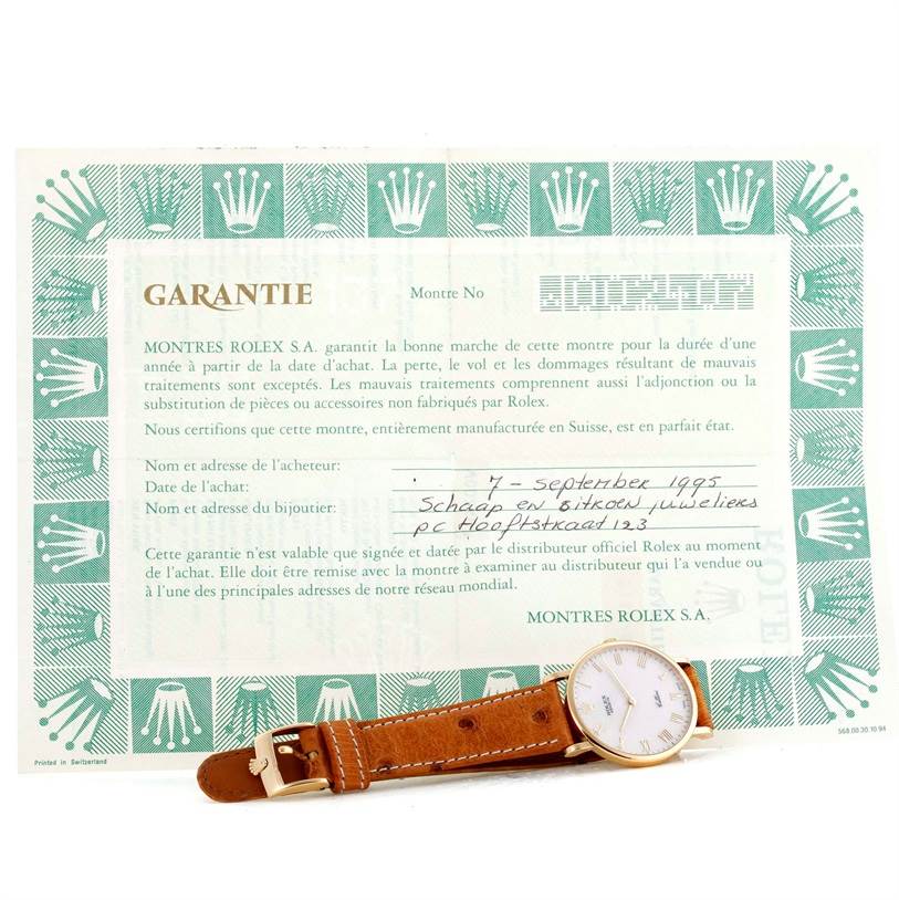 The image shows a Rolex Cellini 5112 Men's Yellow Gold Beige Dial 5112 Men's Yellow Gold Beige Dial model watch with a leather strap, placed in front of a filled-out warranty certificate.