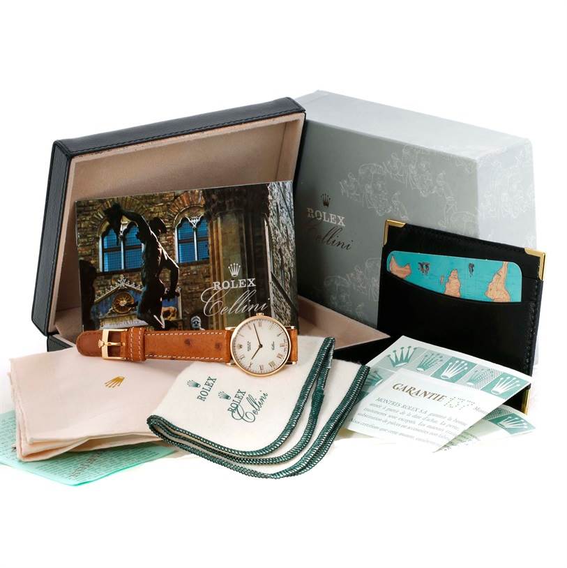 The Rolex Cellini 5112 Men's Yellow Gold Beige Dial 5112 Men's Yellow Gold Beige Dial watch is displayed along with its box, warranty card, manuals, and a black card holder.