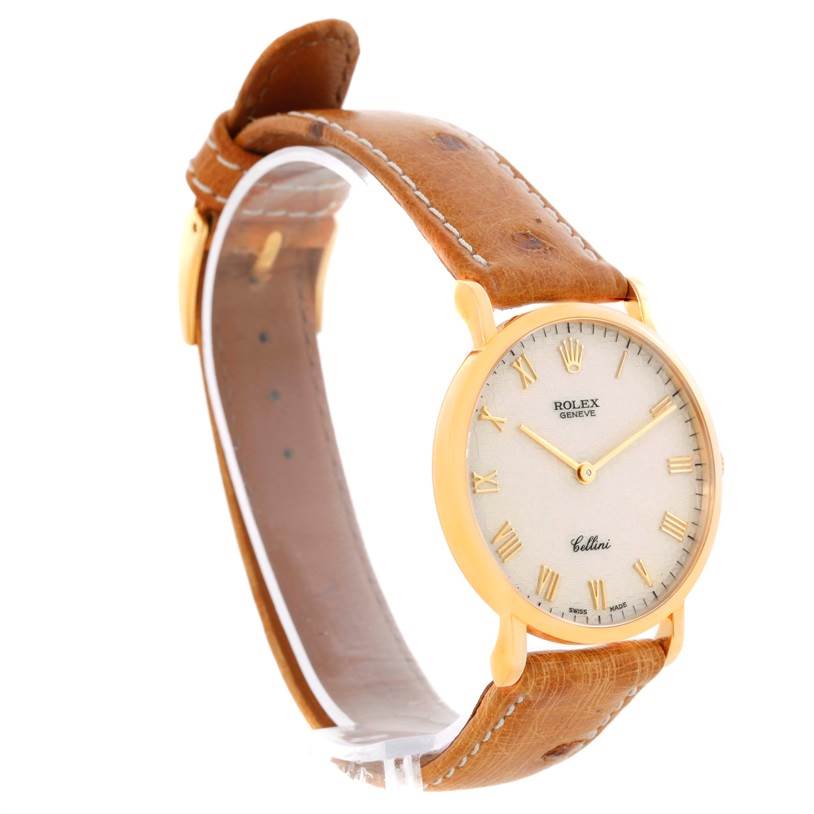 The image shows a side view of a Rolex Cellini 5112 Men's Yellow Gold Beige Dial 5112 Men's Yellow Gold Beige Dial watch, highlighting its face, gold case, and brown leather strap.